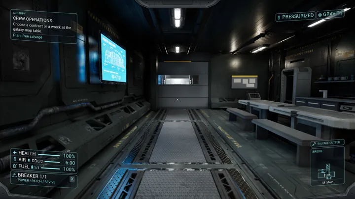 Tables and benches line a dim industrial mess room beneath strip lighting.